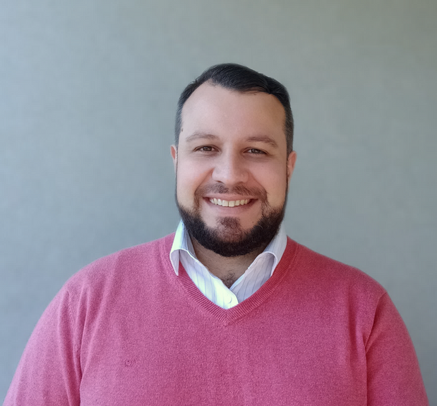 Hombre sonriendo con camisa
Descripción generada automáticamente